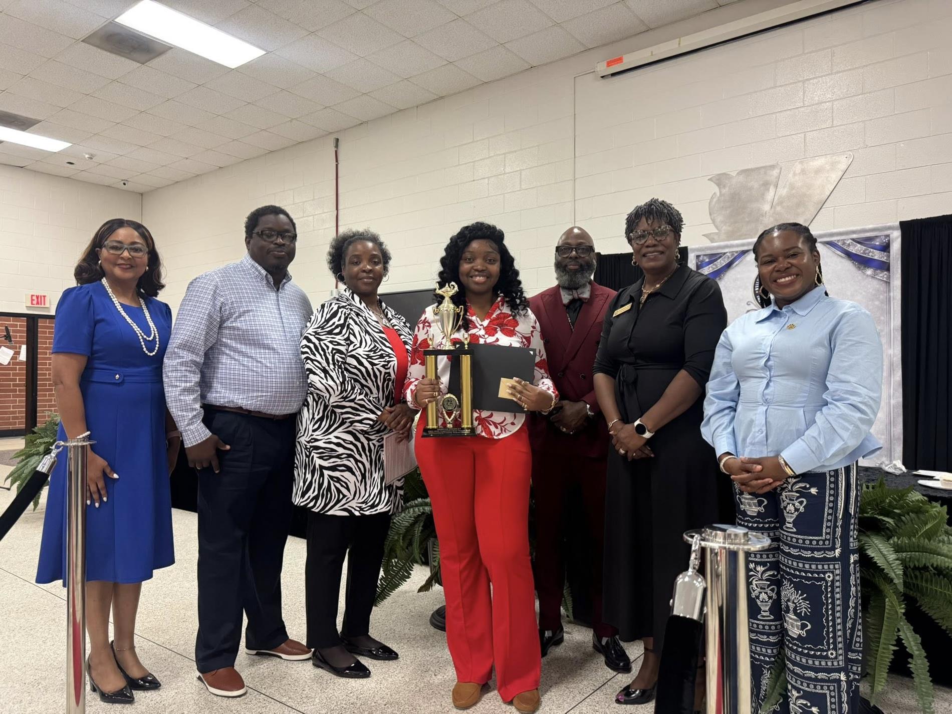 people standing together. one is receiving an award 