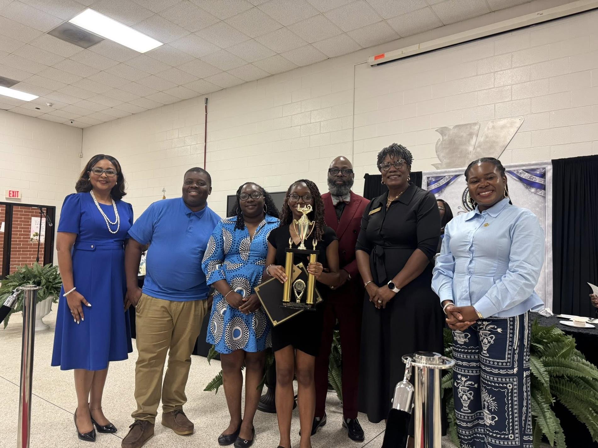people standing together. one is receiving an award 