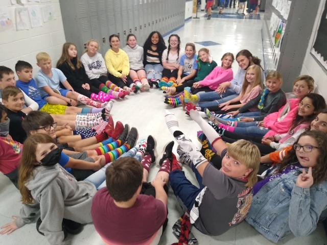 Students in a circle showing off crazy socks