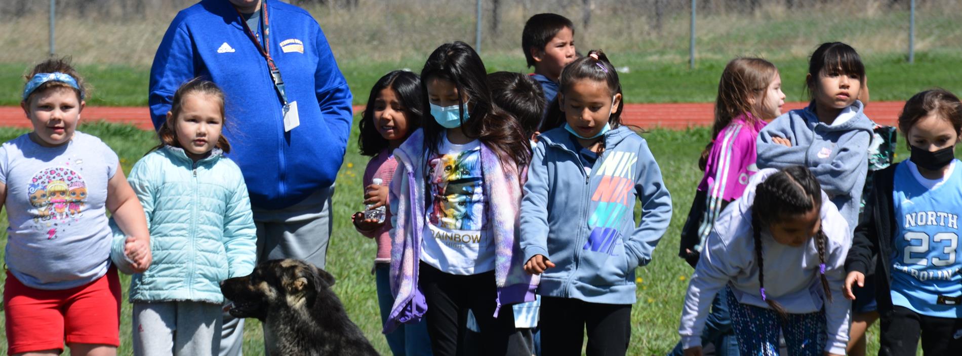 Kindergarten students, teacher, and dog at play day 