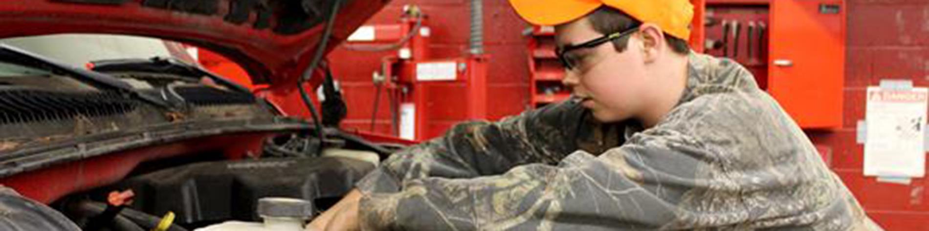 a student works on a truck engine