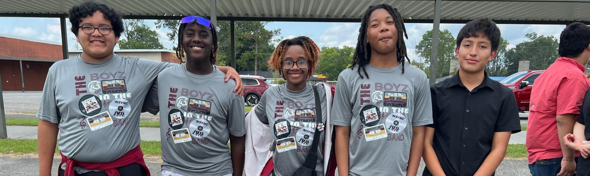 Five students stand in a row for a picture