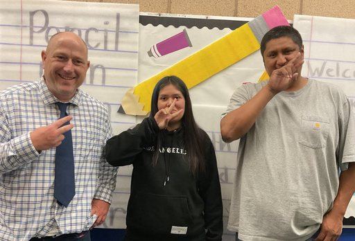 Two middle school staff members in front of the math bulletin board