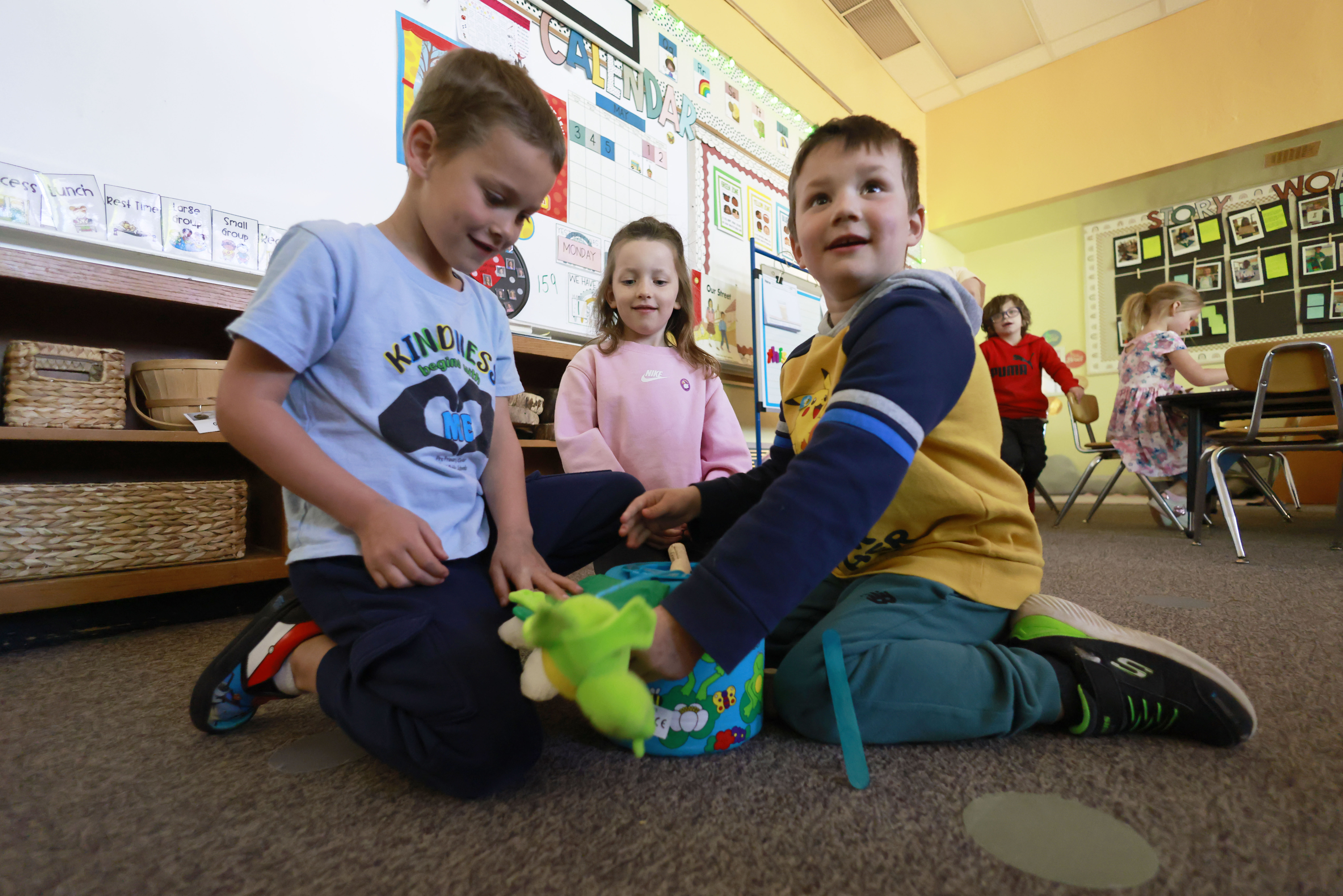 Three young students interact on the floor of a classroom at Carpenter Pre-Primary