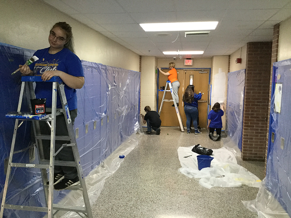 Students volunteering to help paint