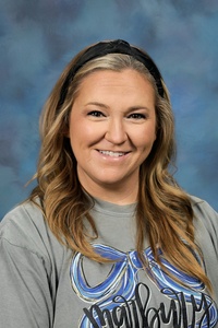 Teacher smiling against a blue background