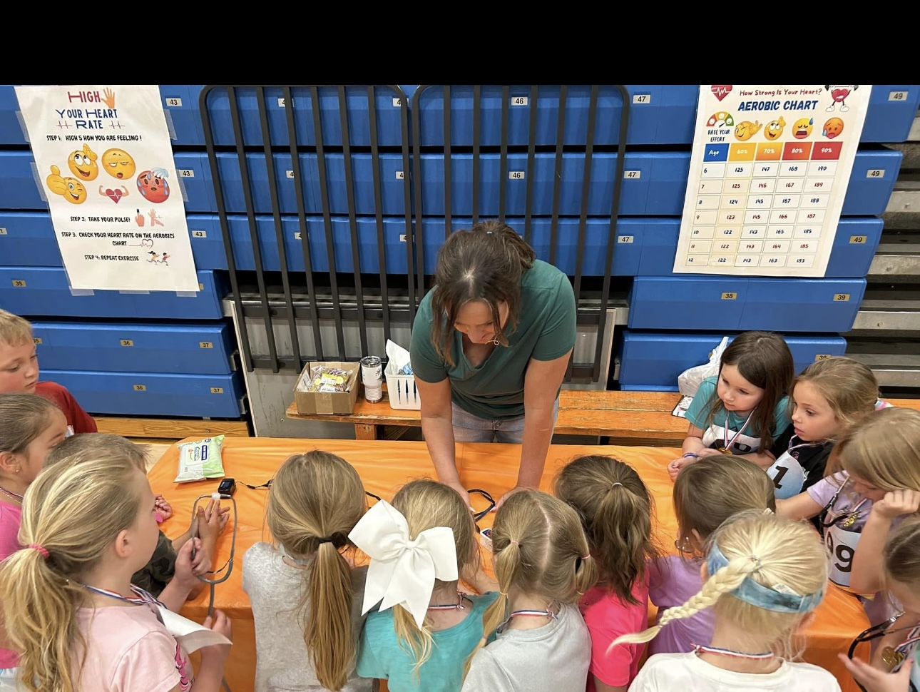 Ms Tarver showing the students how to check their heart rate after jumping at the PTO Fun Day