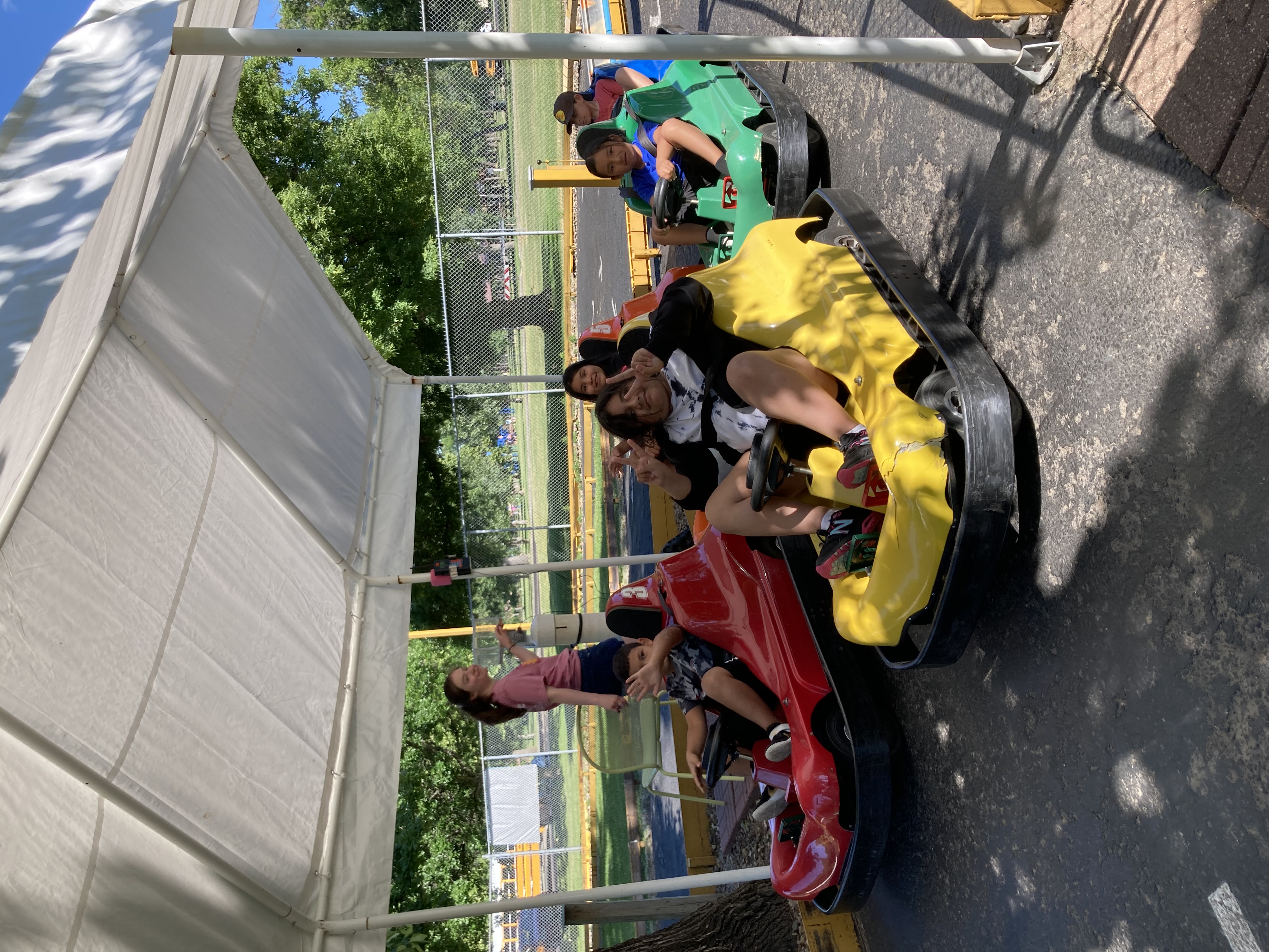 Students waving to camera in bumper cars