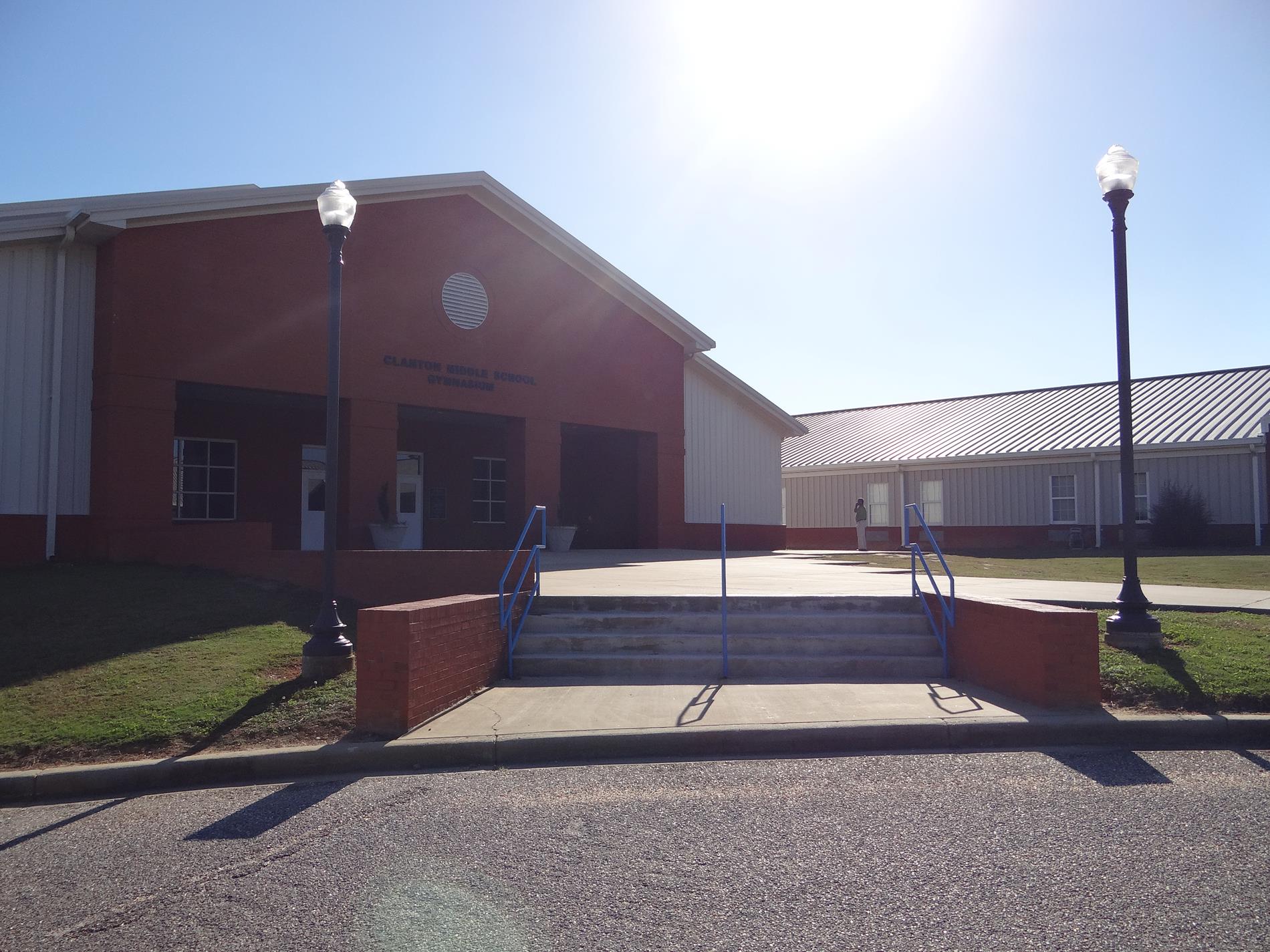 Front Entrance of the gym - a red-brick and white metal building modeled after the school building itself with similar brick columns framing the front doors.