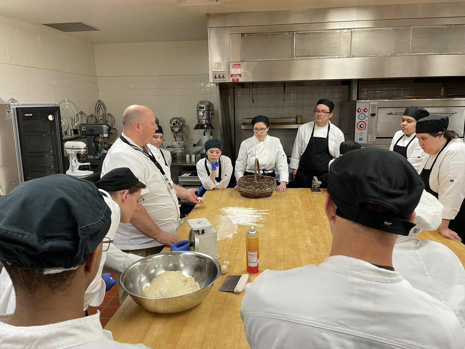Mr. Miles working with students in the kitchen