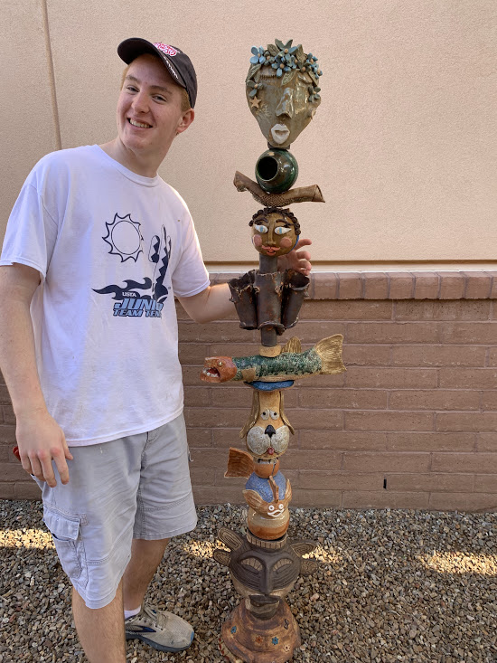 Brett Lewis stands by totem in Lew Sorensen Resource Center courtyard