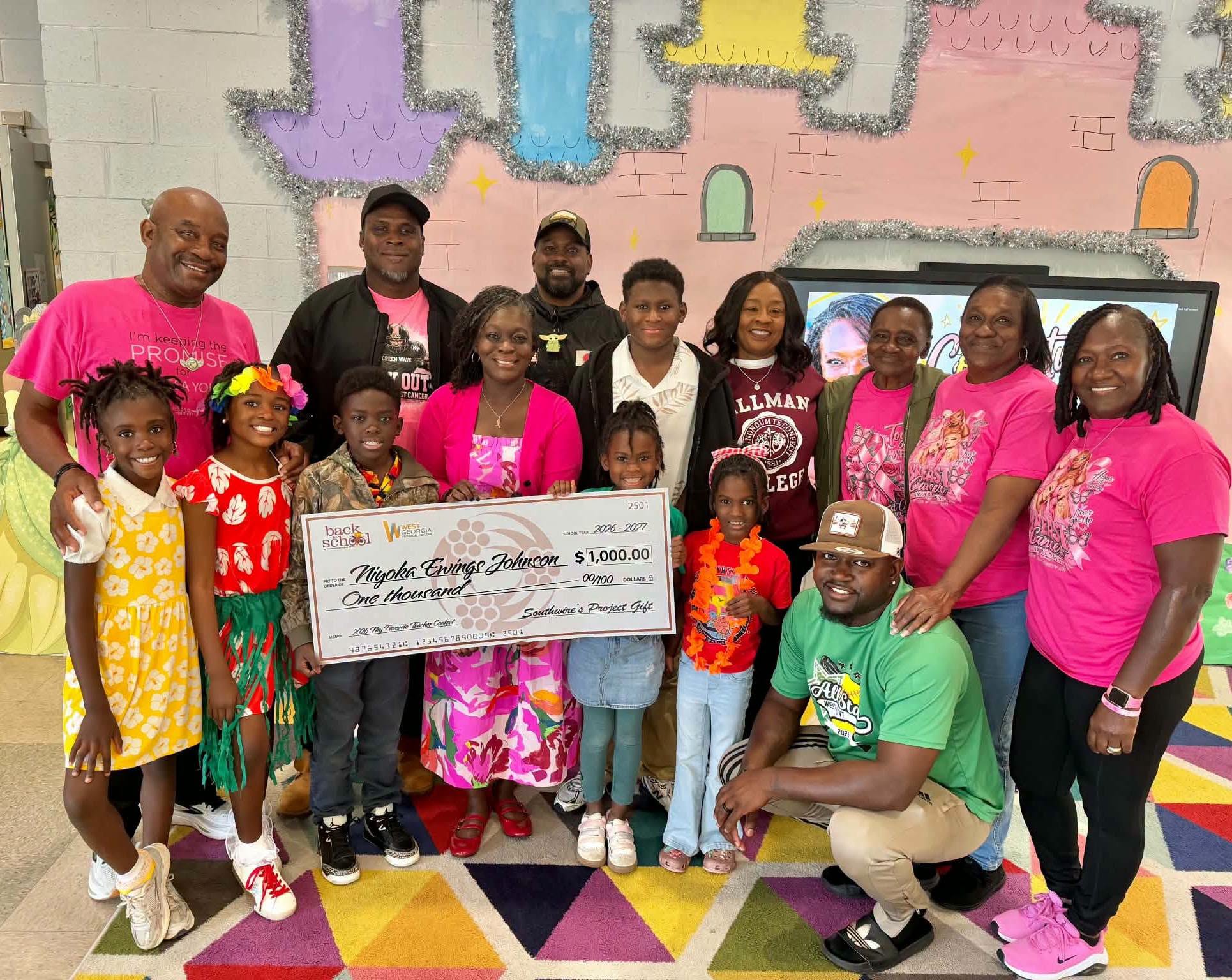 Church Hill Elementary art teacher Niyoka Ewings-Johnson stands with students, family, and supporters while holding a $1,000 award from Southwire’s My Favorite Teacher program.