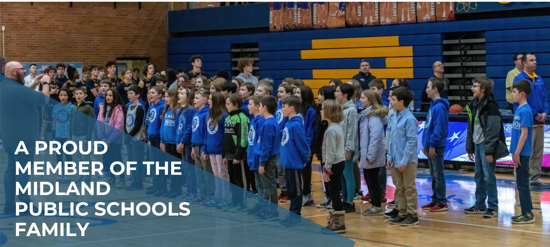 A proud member of the midland public schools family over students in a gym