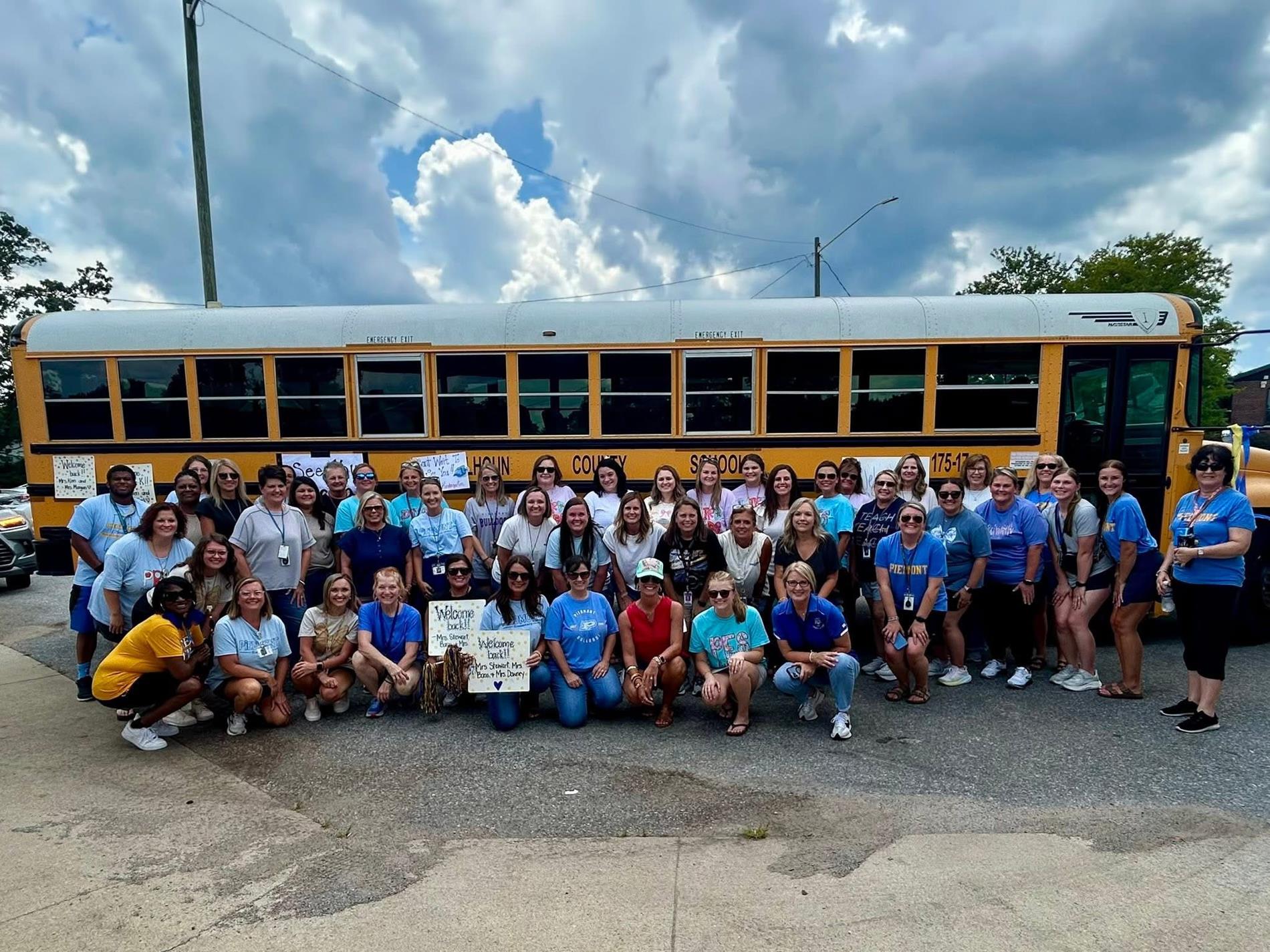 Staff beside a school bus 