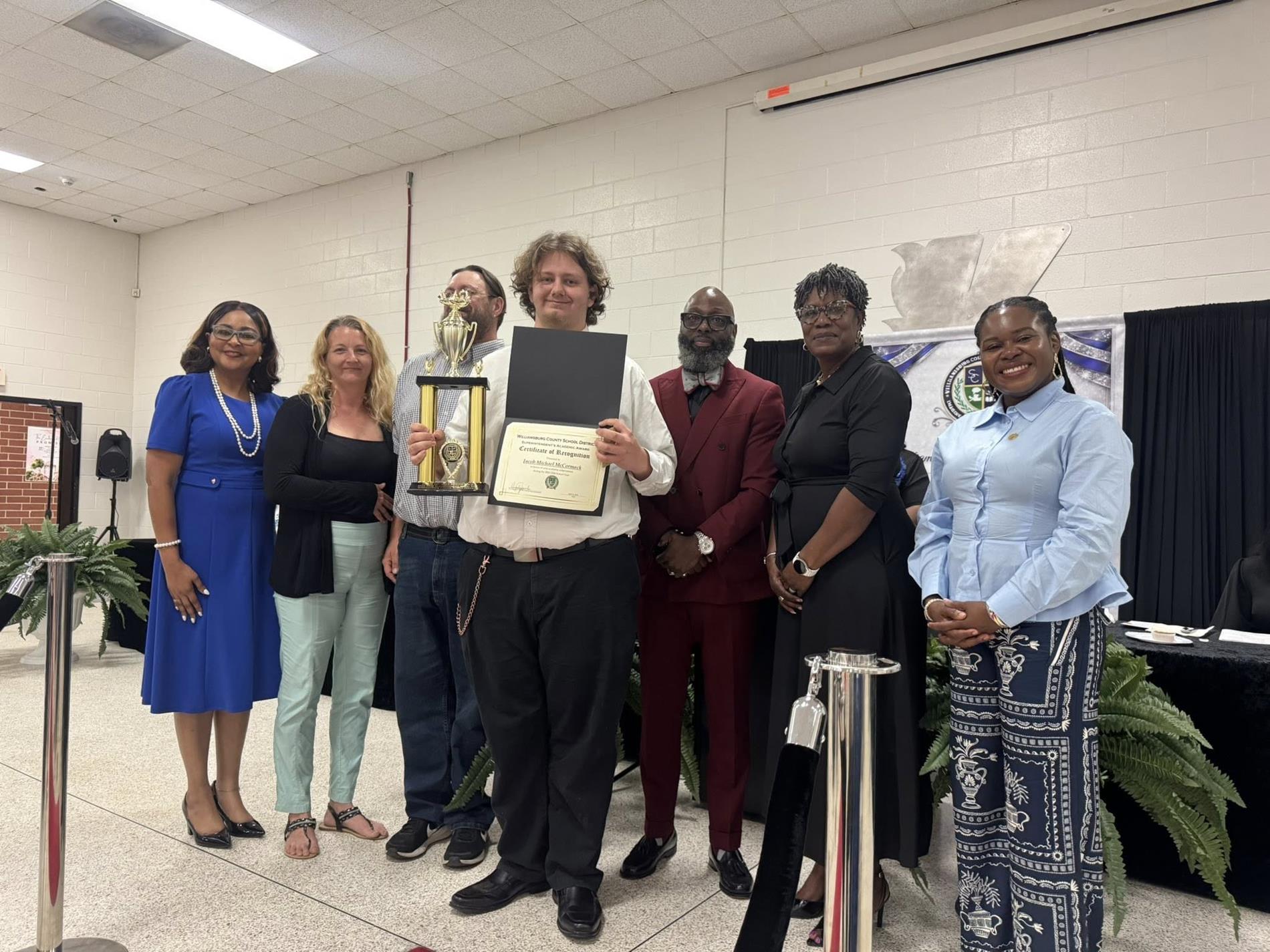 people standing together. one is receiving an award 