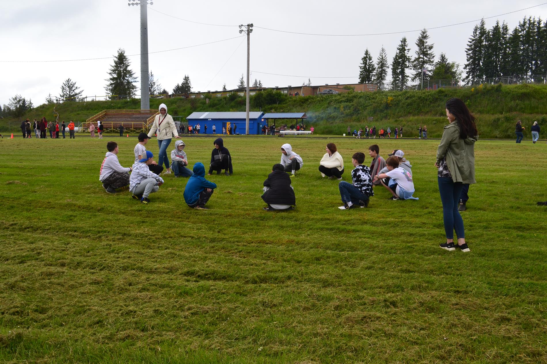Mrs. Linton playing duck, duck, goose with 5th graders