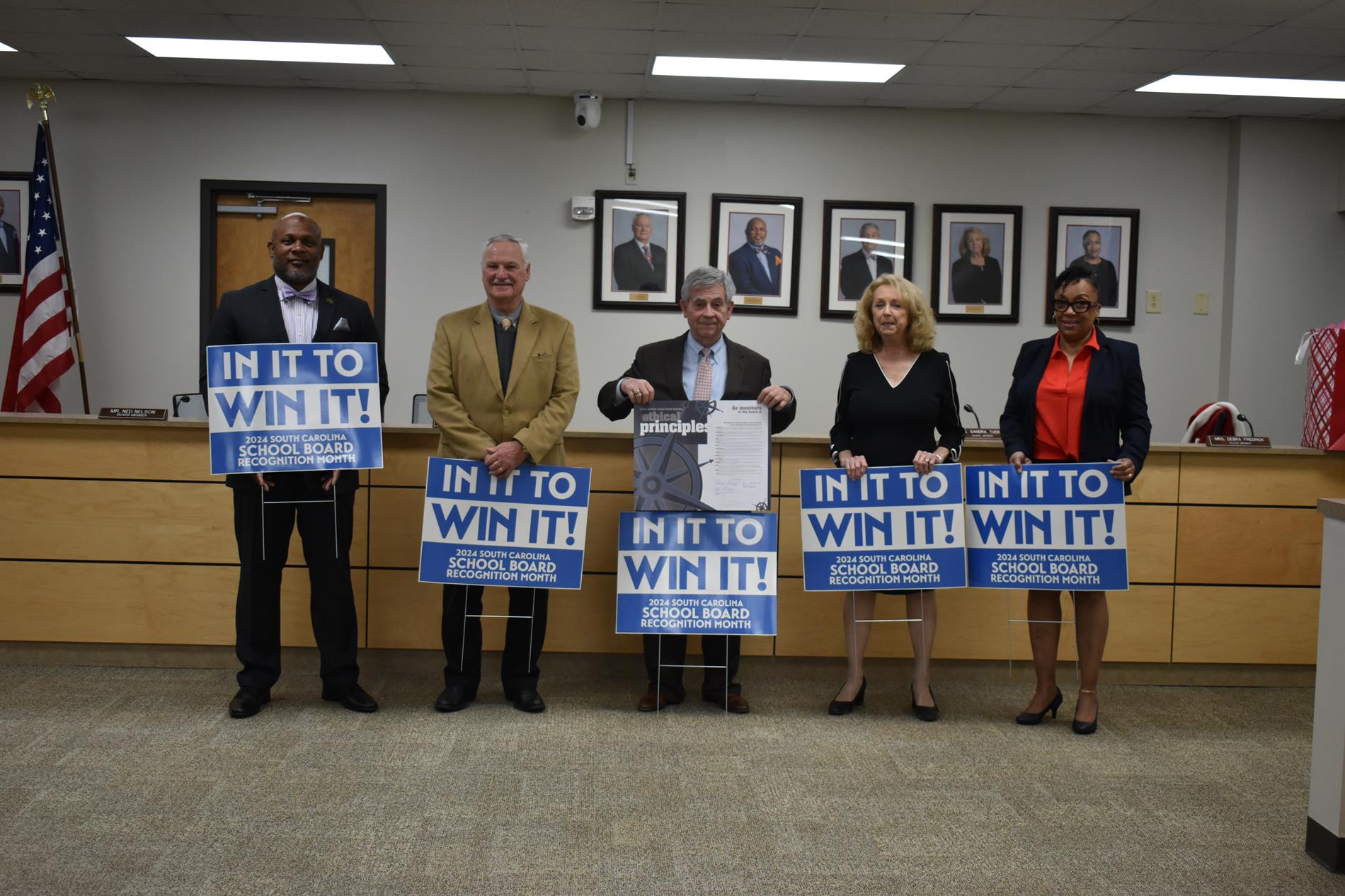Board Members with Ethics Agreement and Yard Signs for the Board Members "In it to Win it"