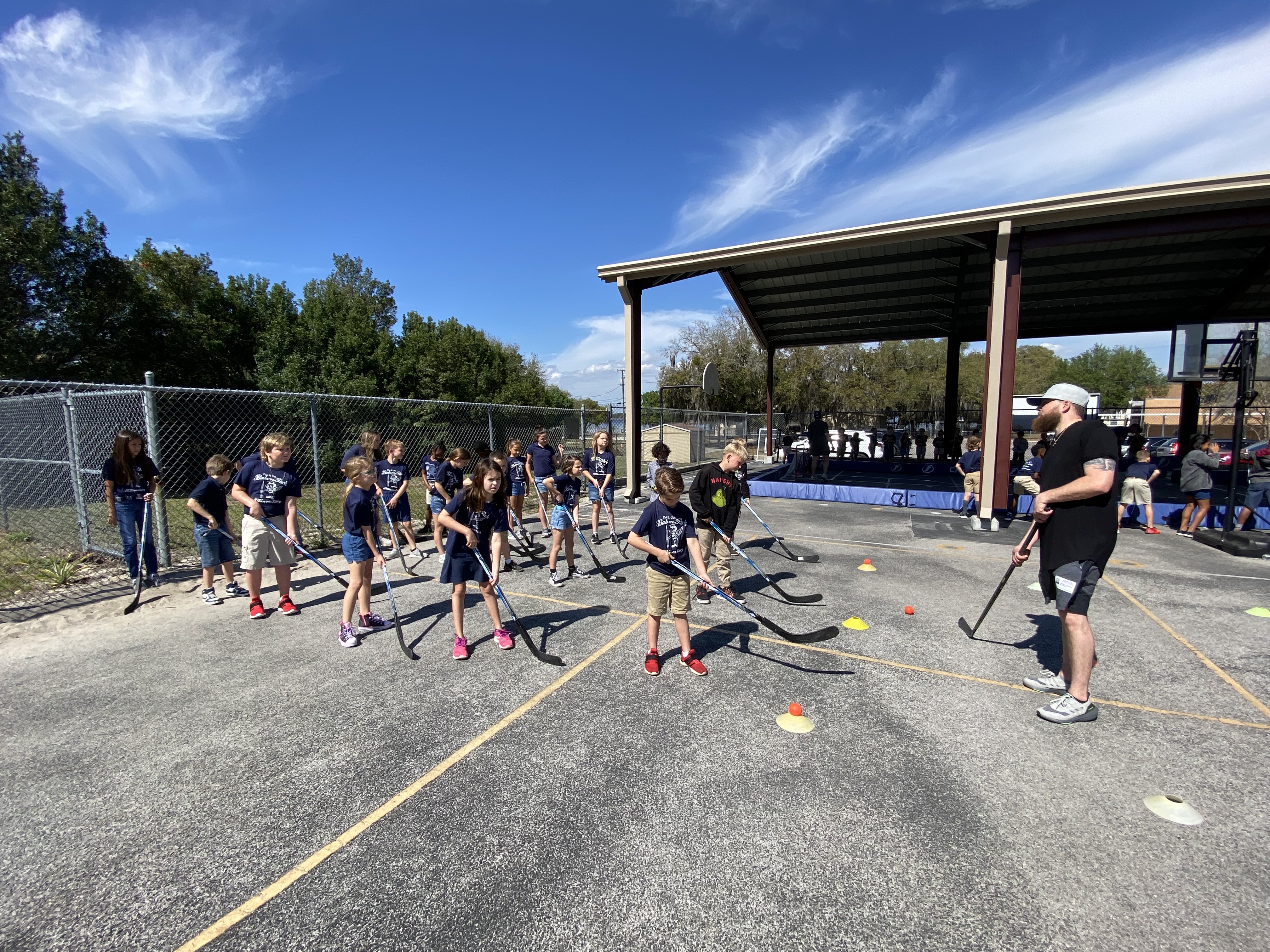 3rd grade students learning hockey techniques.