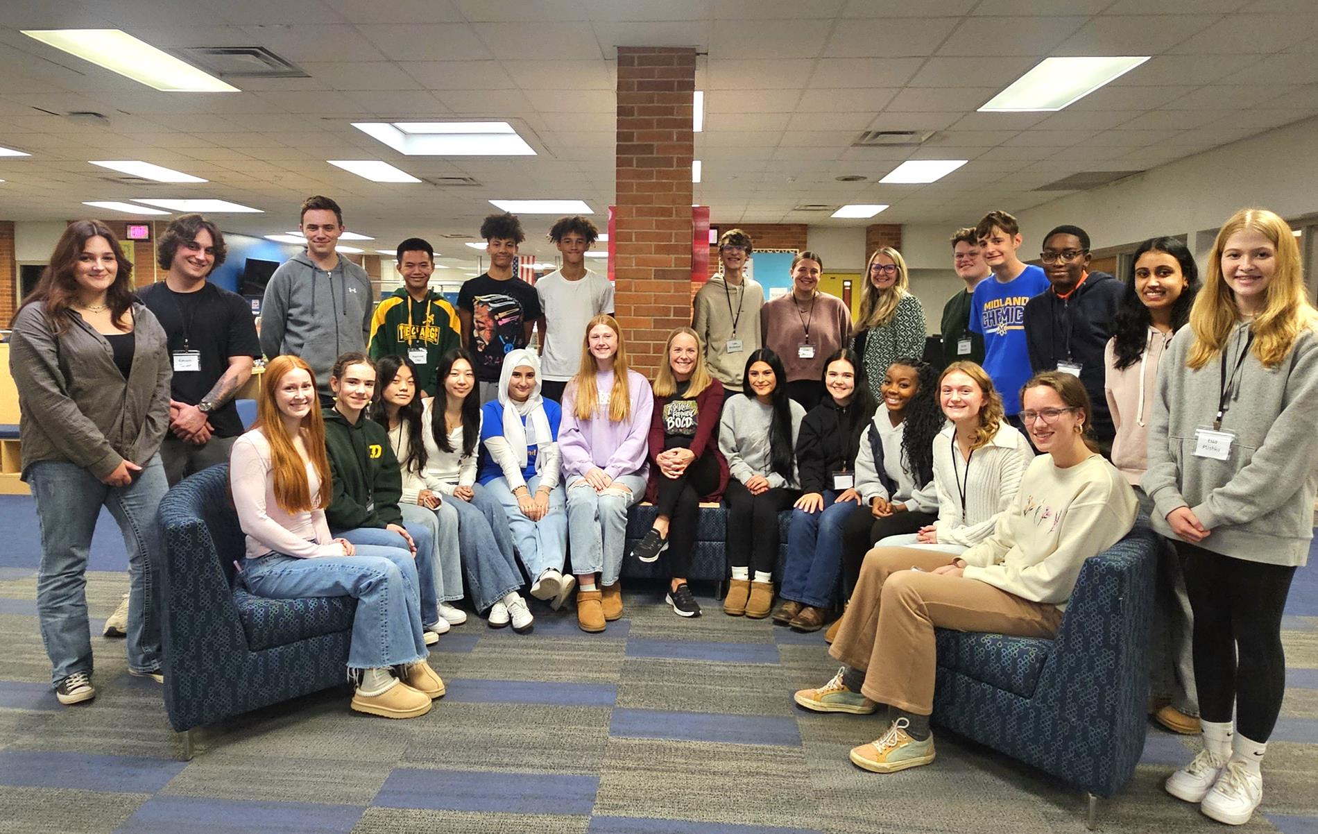 The 2025-2026 SSAT sit around a couch in the Midland High School media center