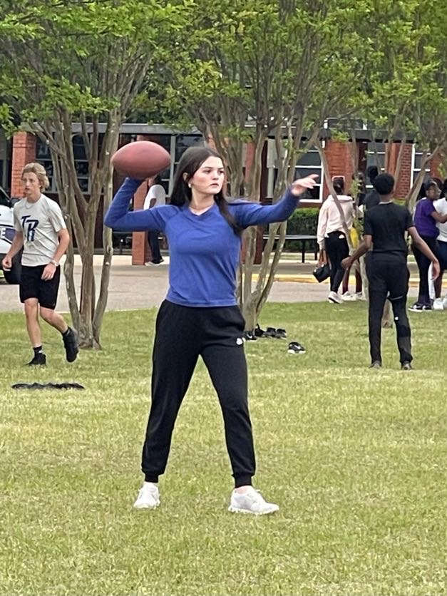 girl in purple shirt throwing football