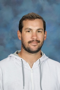 Teacher smiling against a blue background