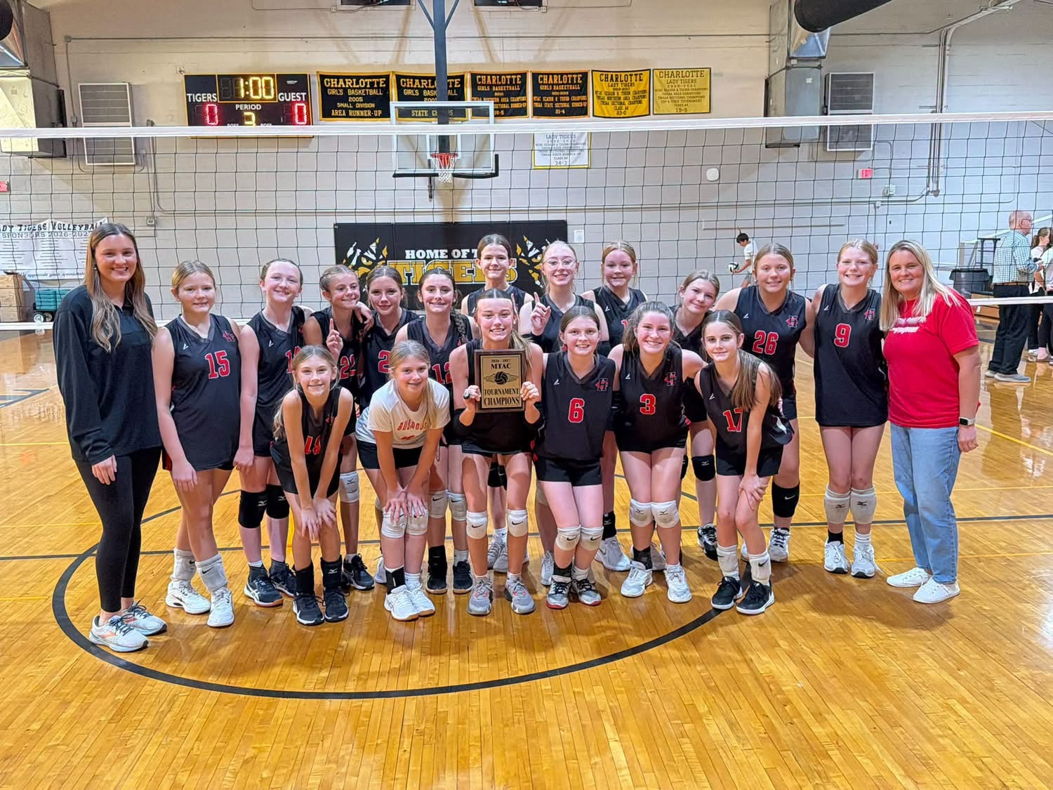 HCMS Volleyball celebrating their championship with their trophy