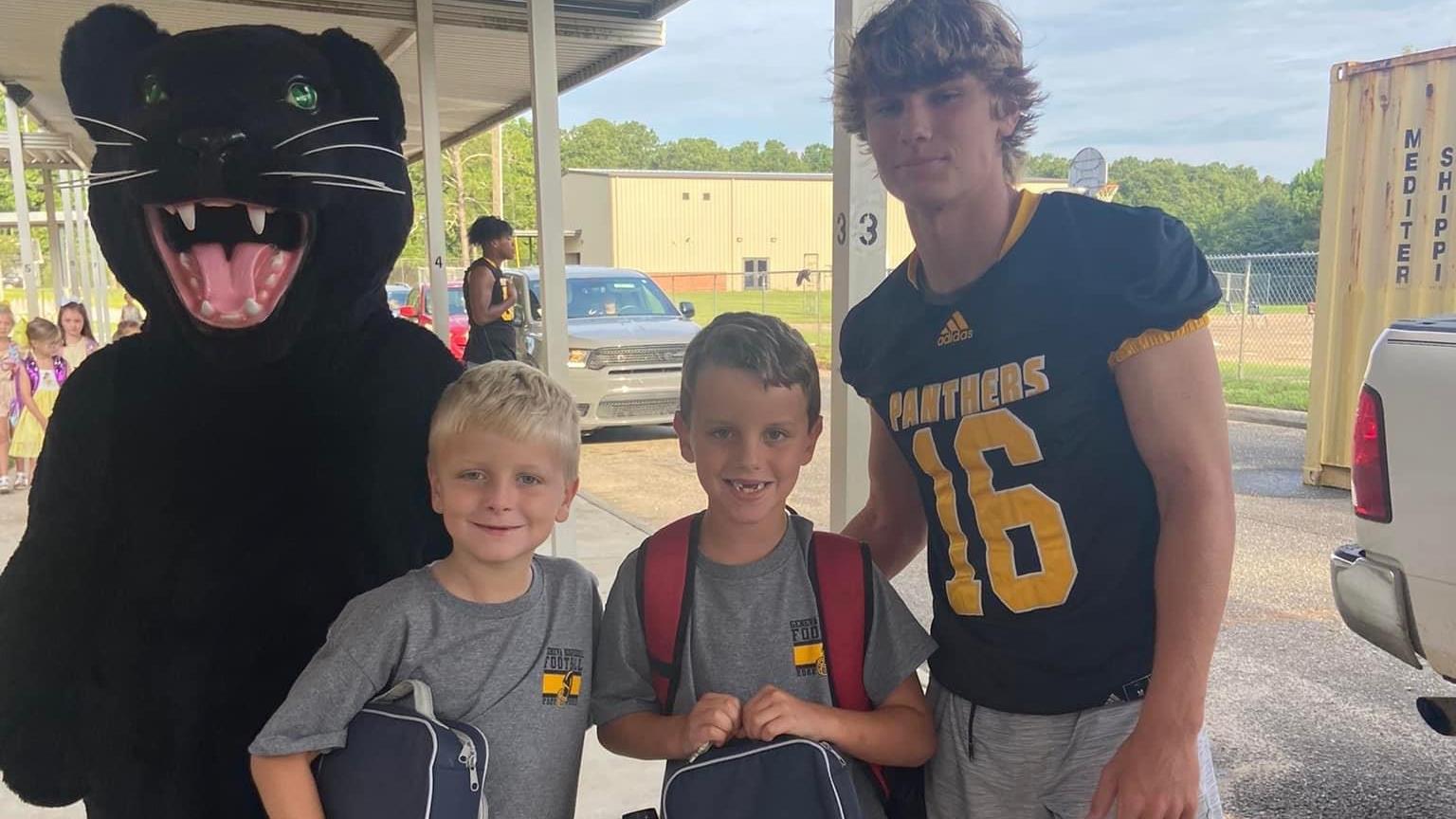 carline students with mascot and football player