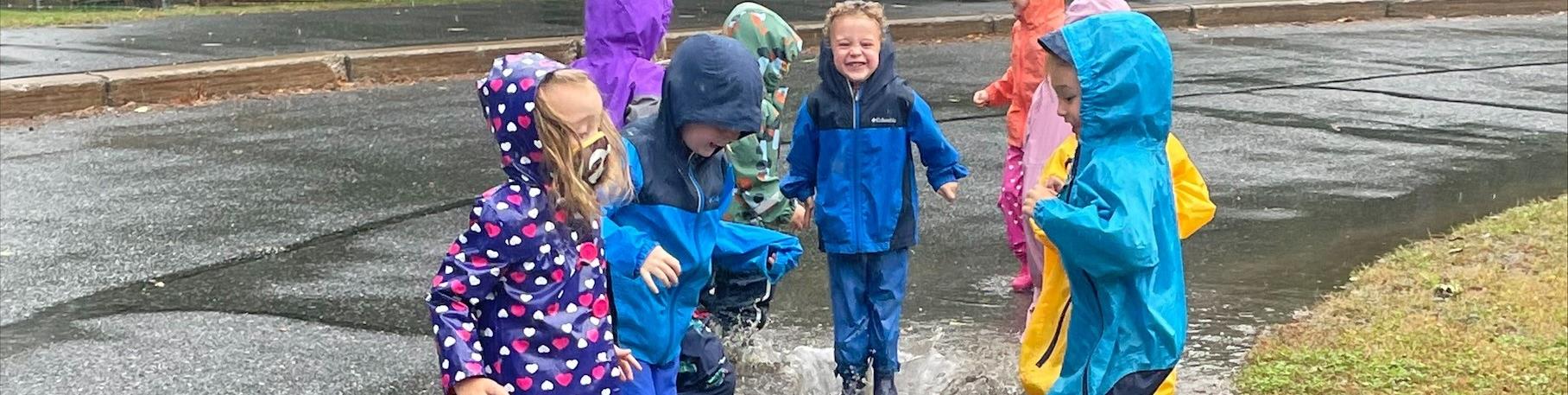 Preschool Students play in puddles