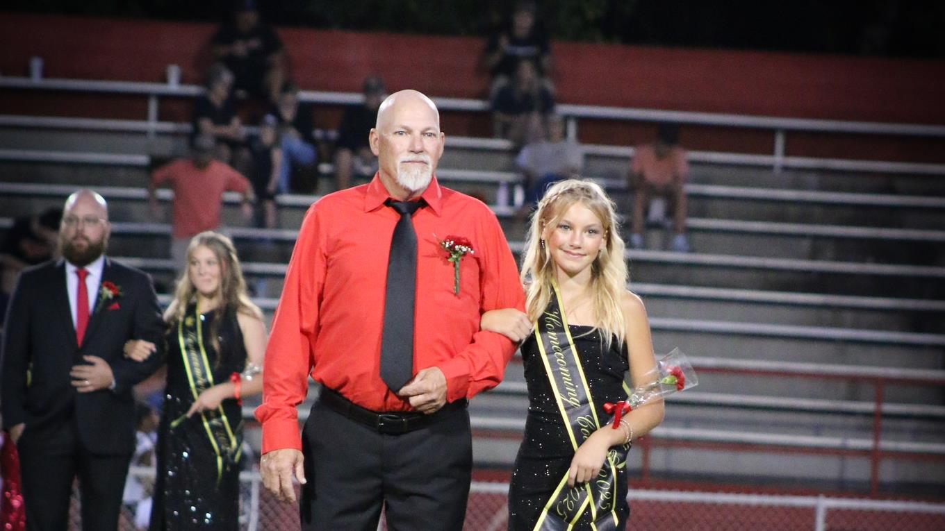 Homecoming attendant in a black dress with escort