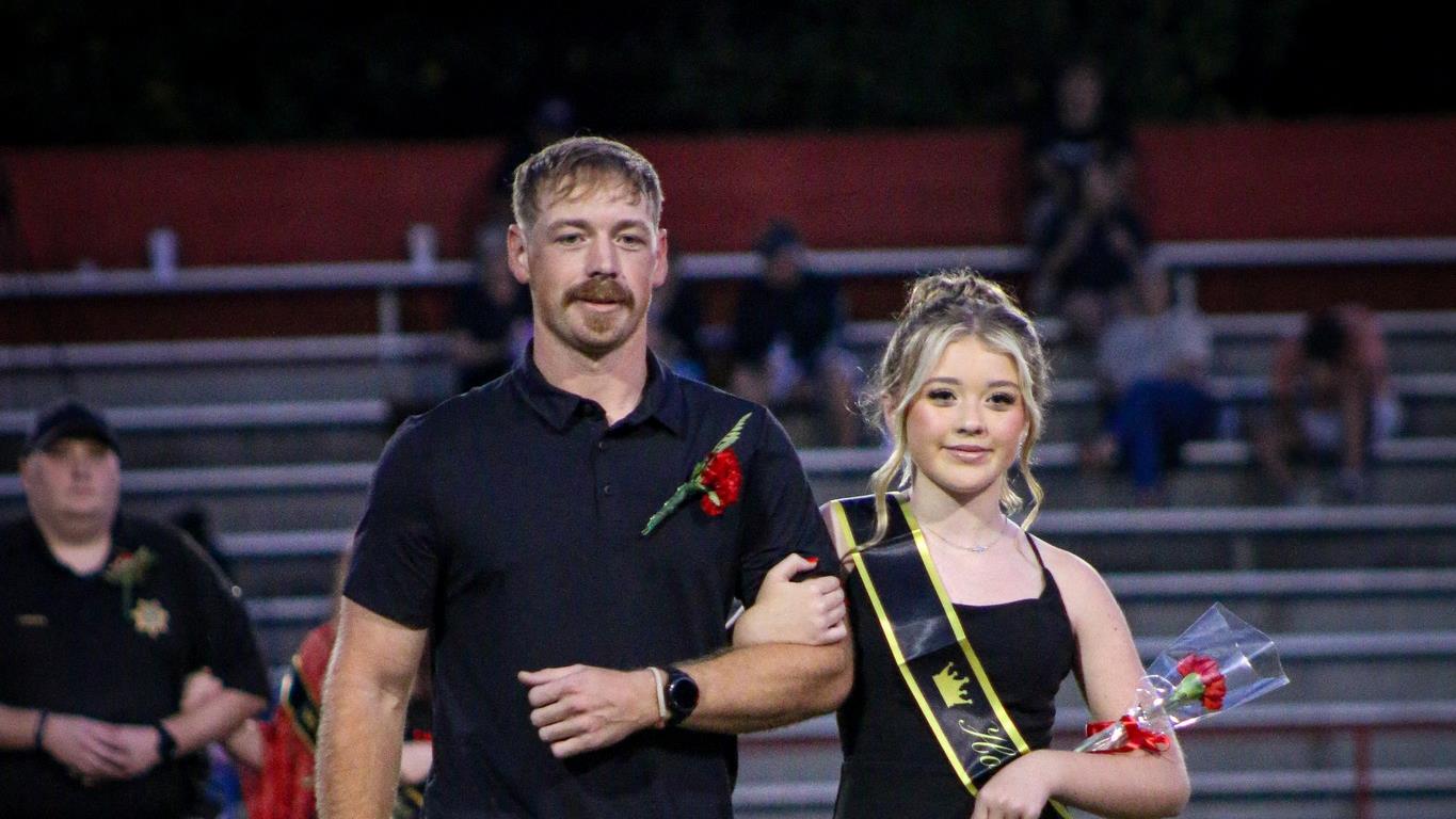 Homecoming attendant in a black dress with escort