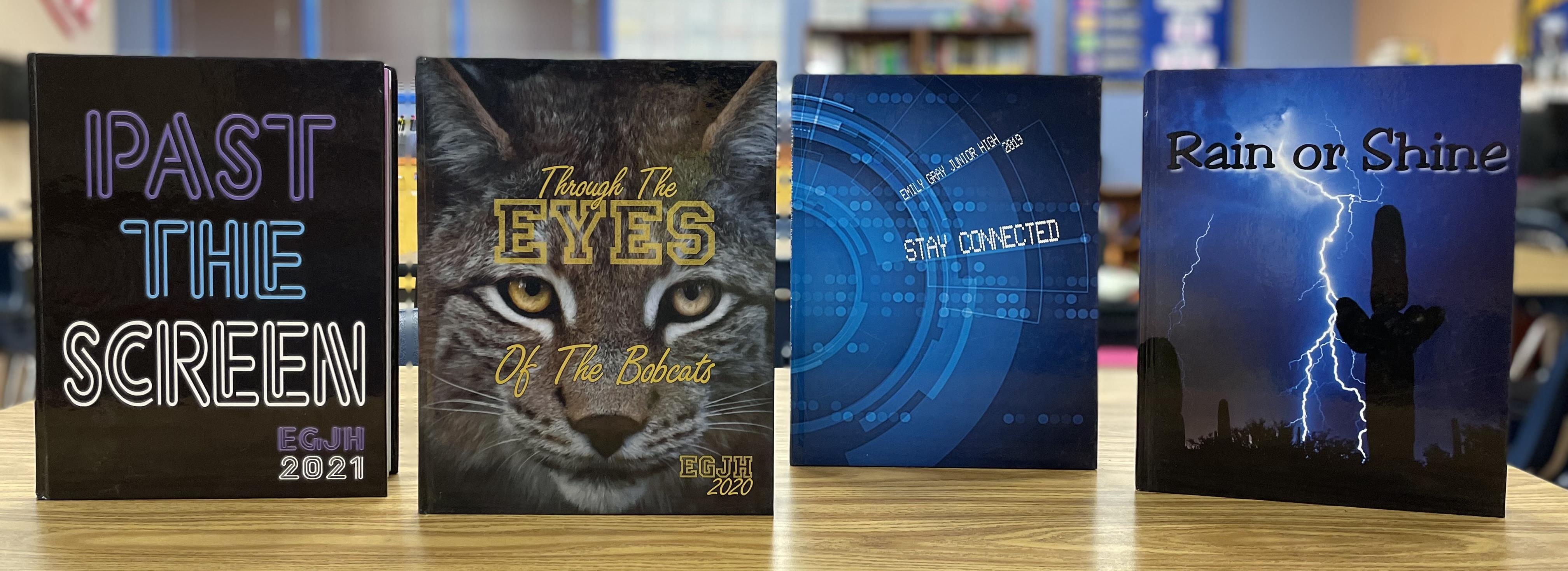 Copies of the Emily Gray yearbook titled (from left to right): Past the Screen, Through the Eyes of the Bobcats, Stay Connected, and Rain or Shine.