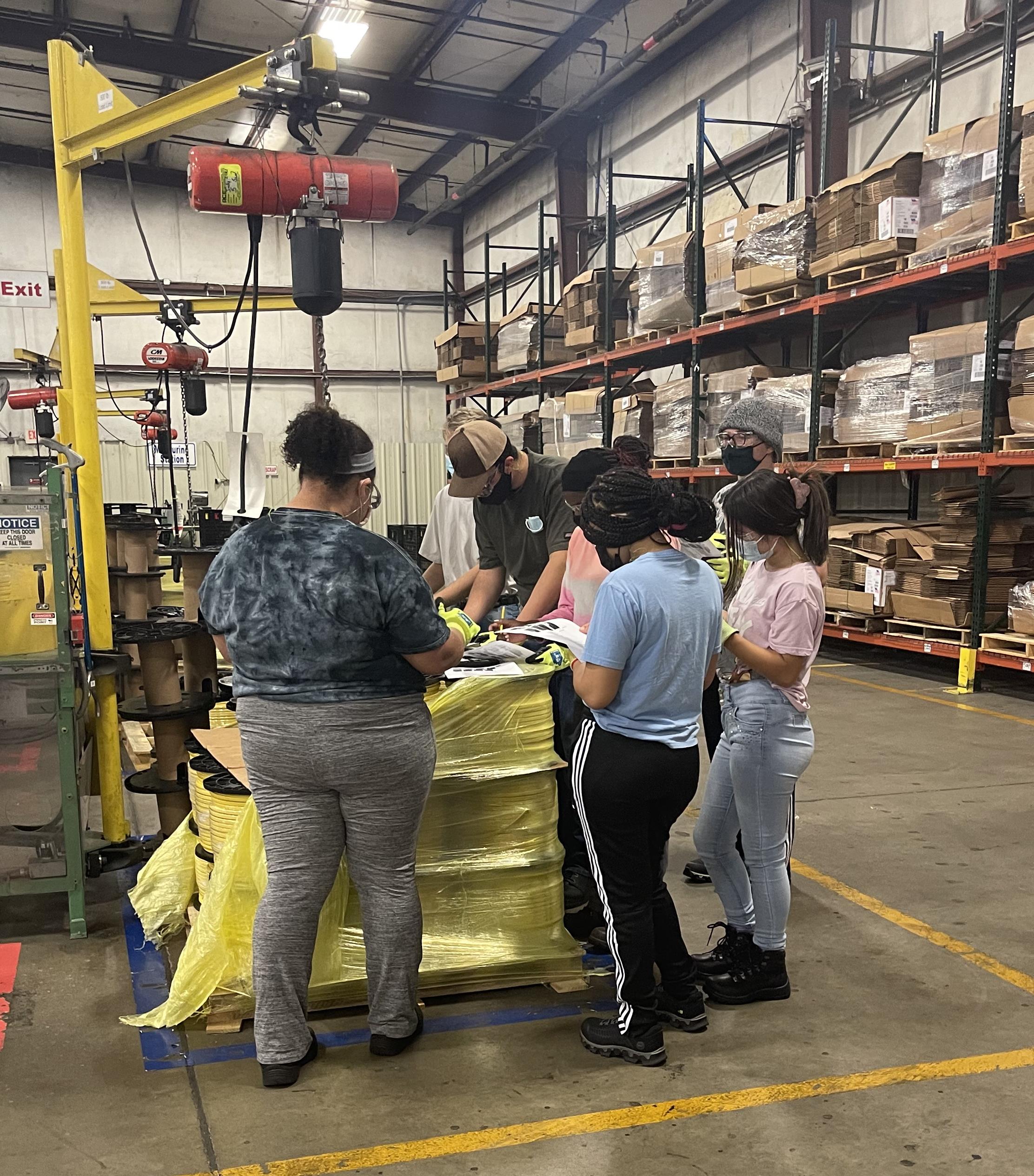 Students working with Southwire full time employees to learn the different machines in the plant.