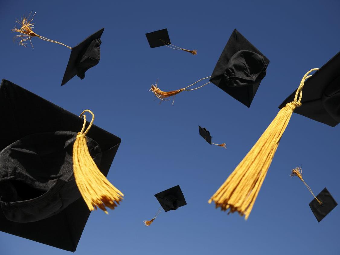 Image of graduation caps thrown in the air