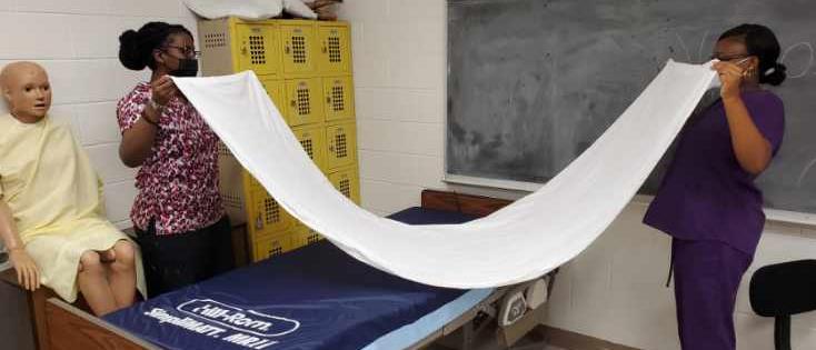 students making up medical bed 