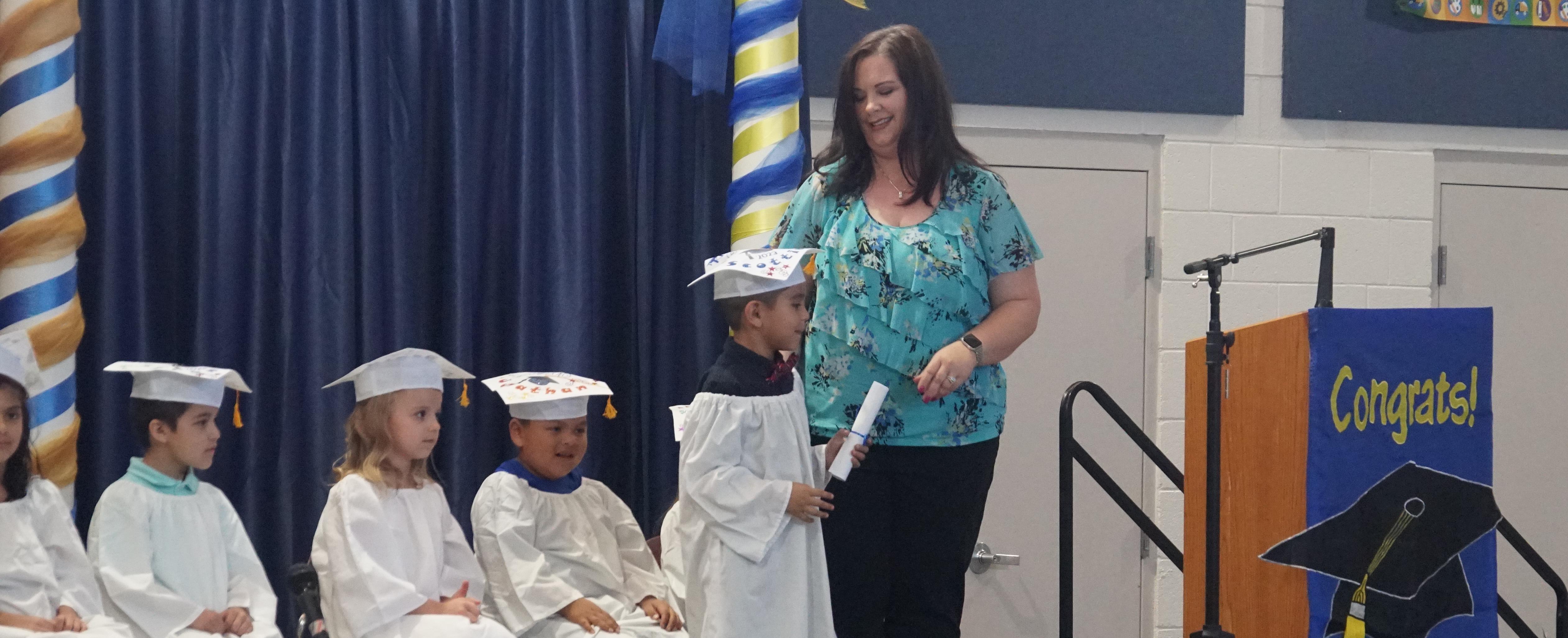Student receiving diploma at Kindergarten graduation