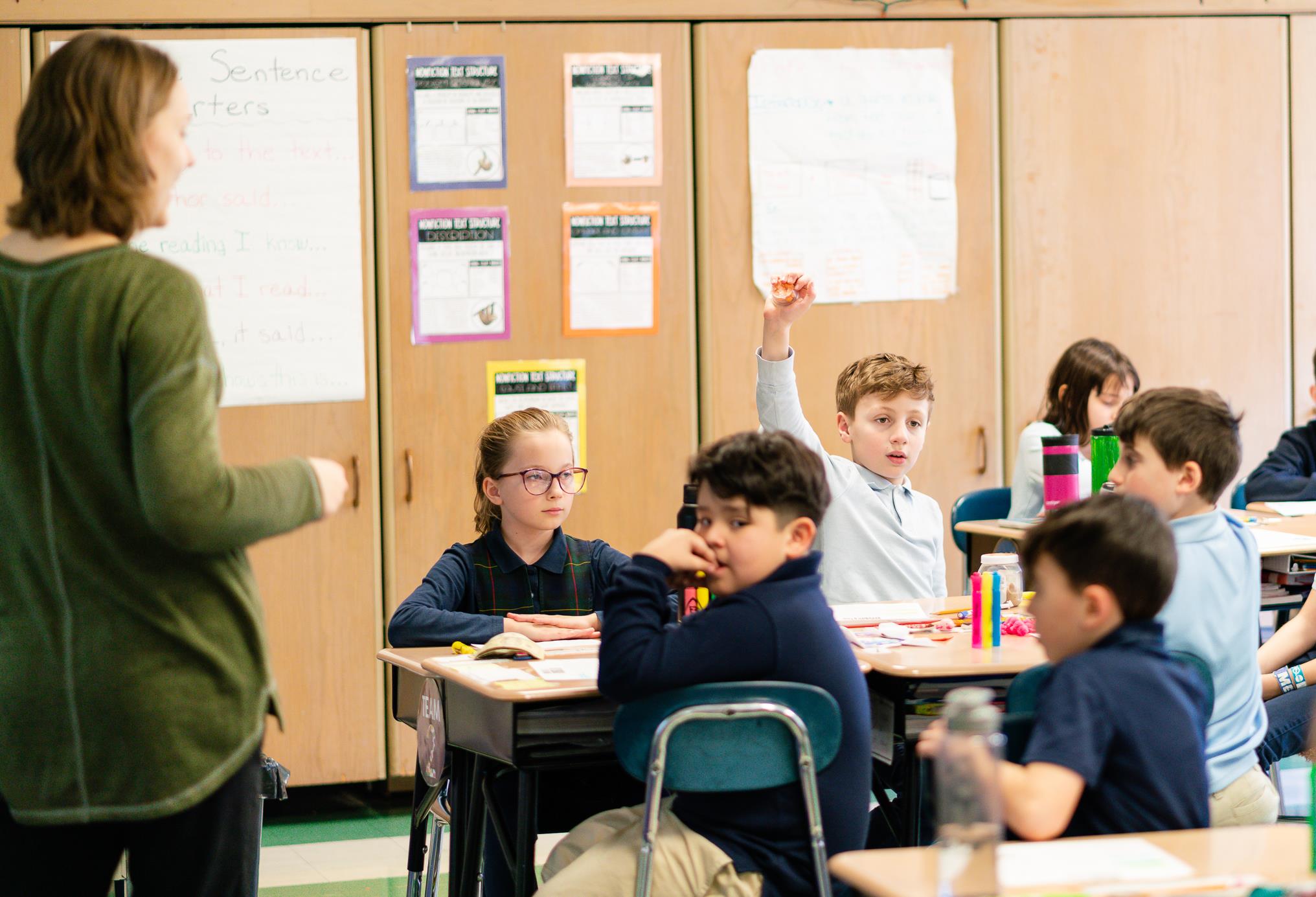 Teacher teaching with students raising hands Teacher teaching with students raising hands