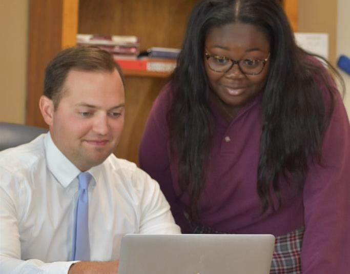 teacher showing student info on laptop teacher showing student info on laptop