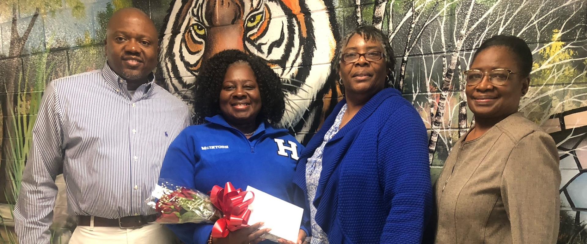 school counselor presented with flowers from principal and assistant principal