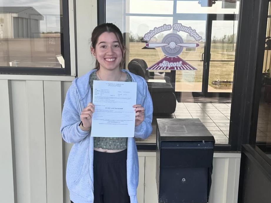 Valerie Contreras holds proof of her passing the Private Pilot Knowledge exam.