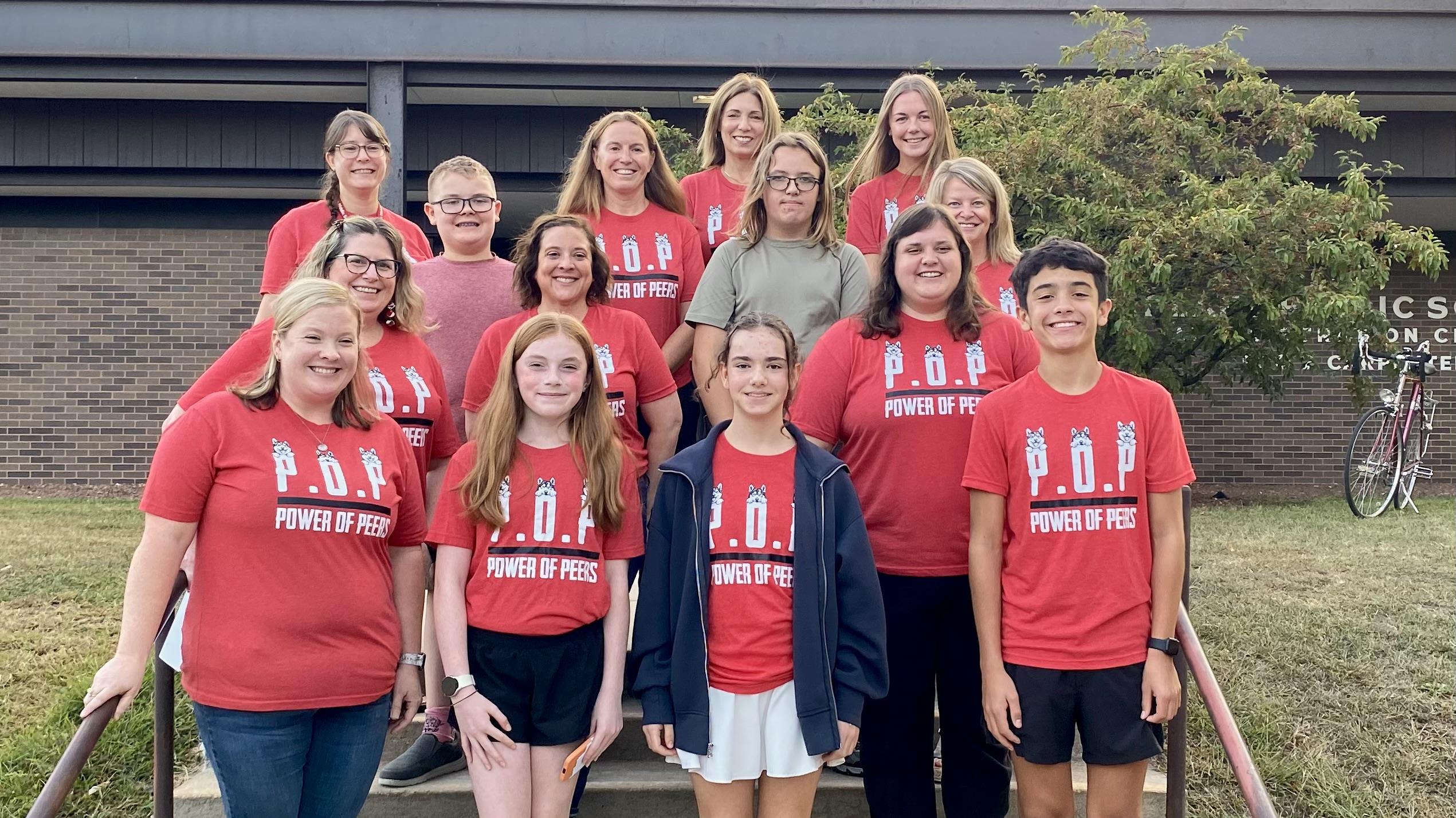 a group of students and staff posing on stairs