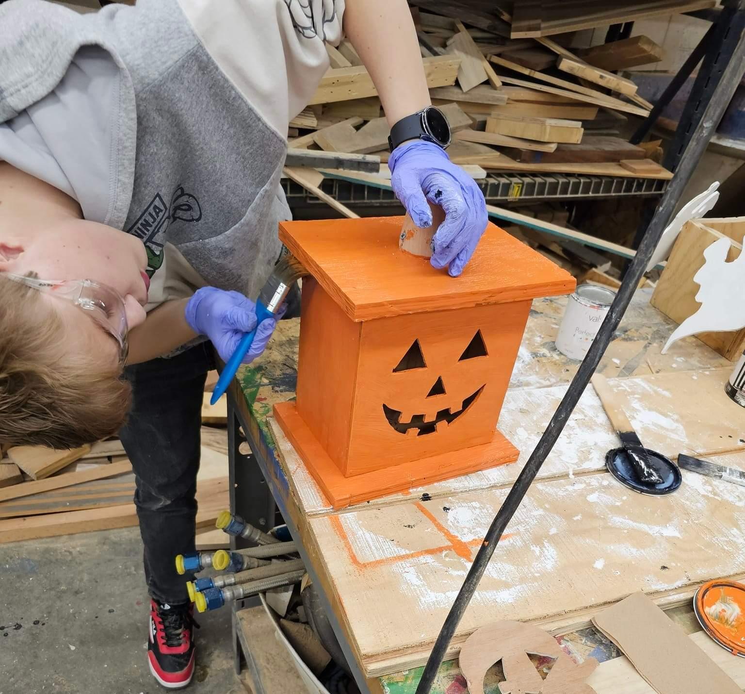 Student works on wooden pumpkin