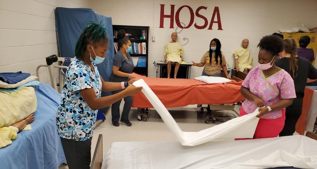 students making up medical bed 