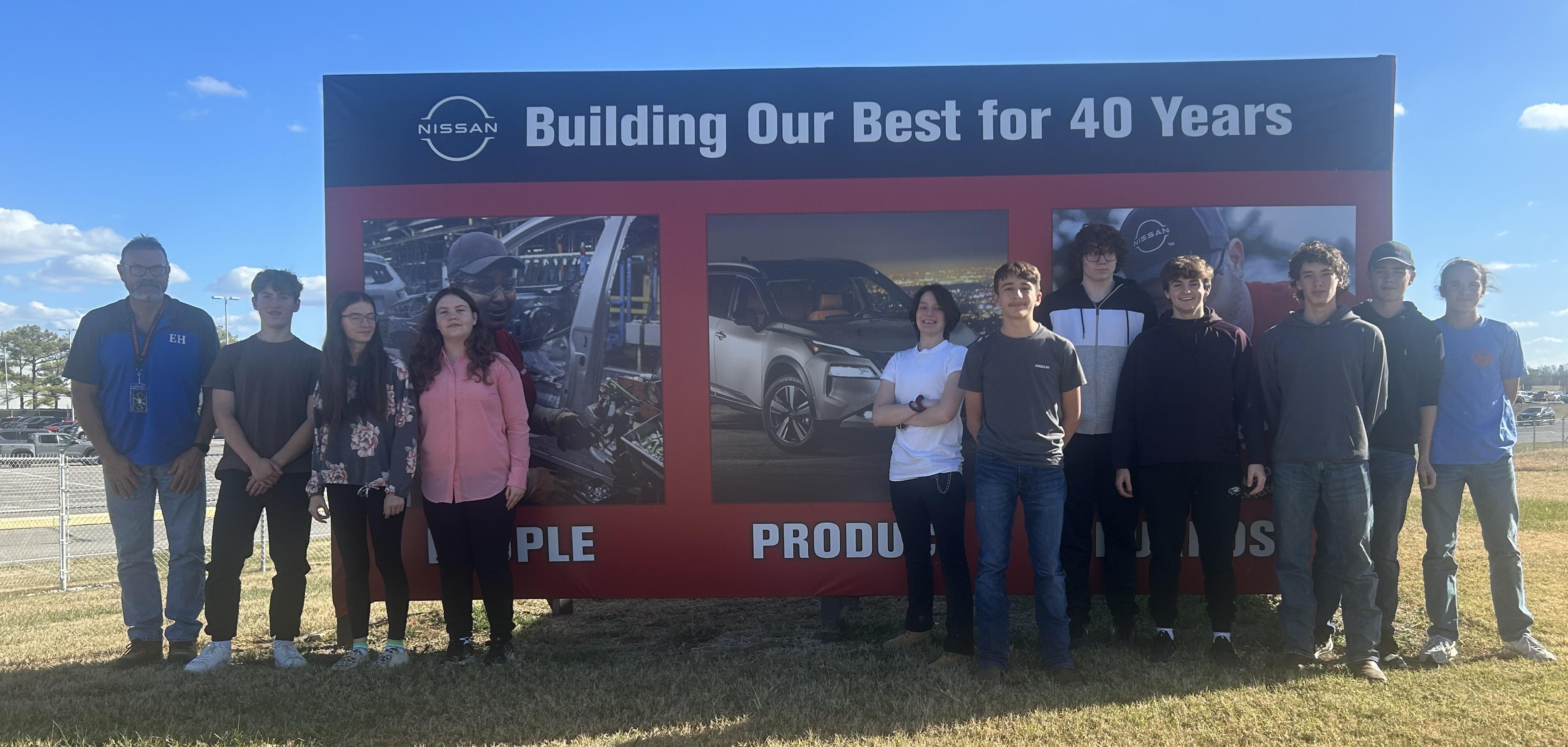 Building Trades Students posing for a group picture in front of a sign