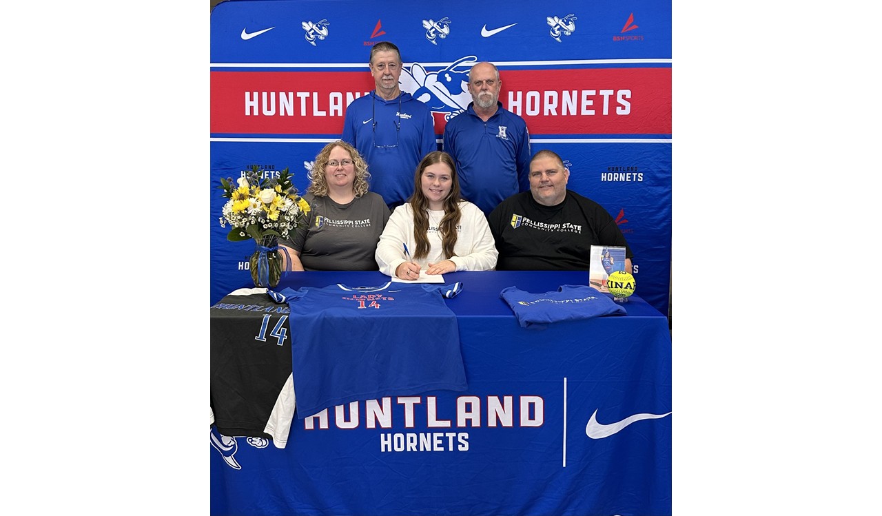 Photo of Kinah Mason signing with Pellissippi State Community College to further her softball career. In the photo is Kinah, her mother on the left and father on the right. Coach Rob and Coach Tipps standing behind them. There is a table in front of them all with a vase of yellow and white flowers,  Kinah's Huntland Jerseys and a Pellissippi Tshirt as well as a photo of Kinah in her softball uniform and a neon yellow softball with her name on it. The background of the photo is Huntland colors with Hornets, Nike logos, and BSN Sports logos.